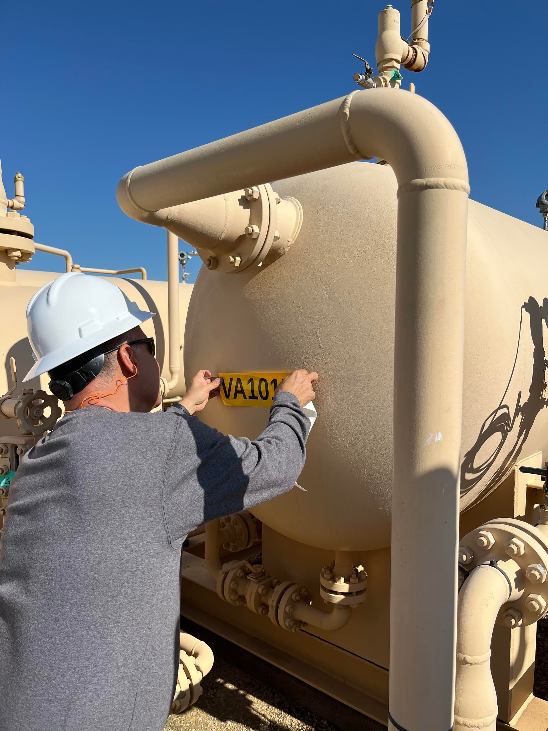 Técnico colocando etiqueta de identificación en equipo industrial